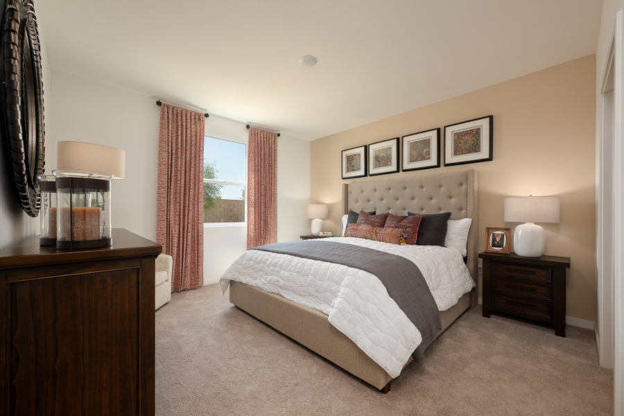 A bedroom with a bed and lamps.