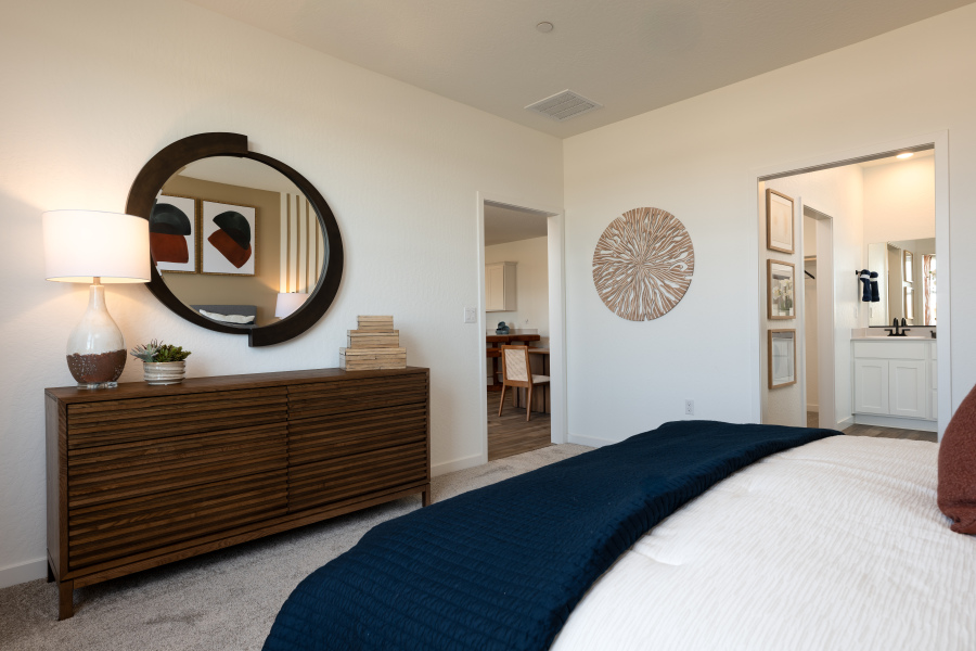 A bedroom with a bed and a mirror.