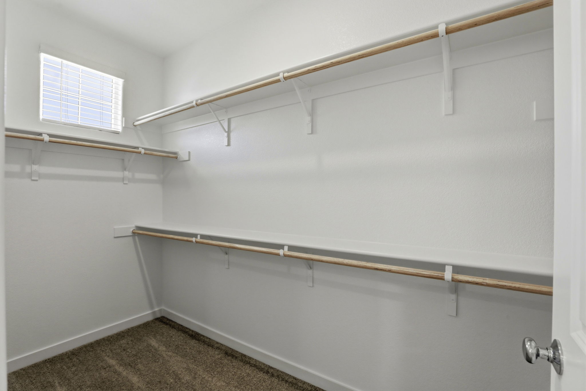 A white wall with a metal bar.