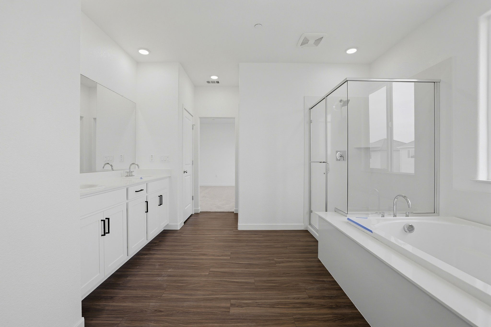 A bathroom with white cabinets.