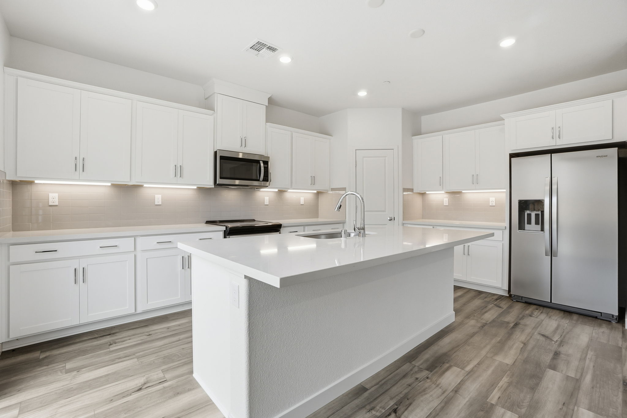 A kitchen with white cabinets.