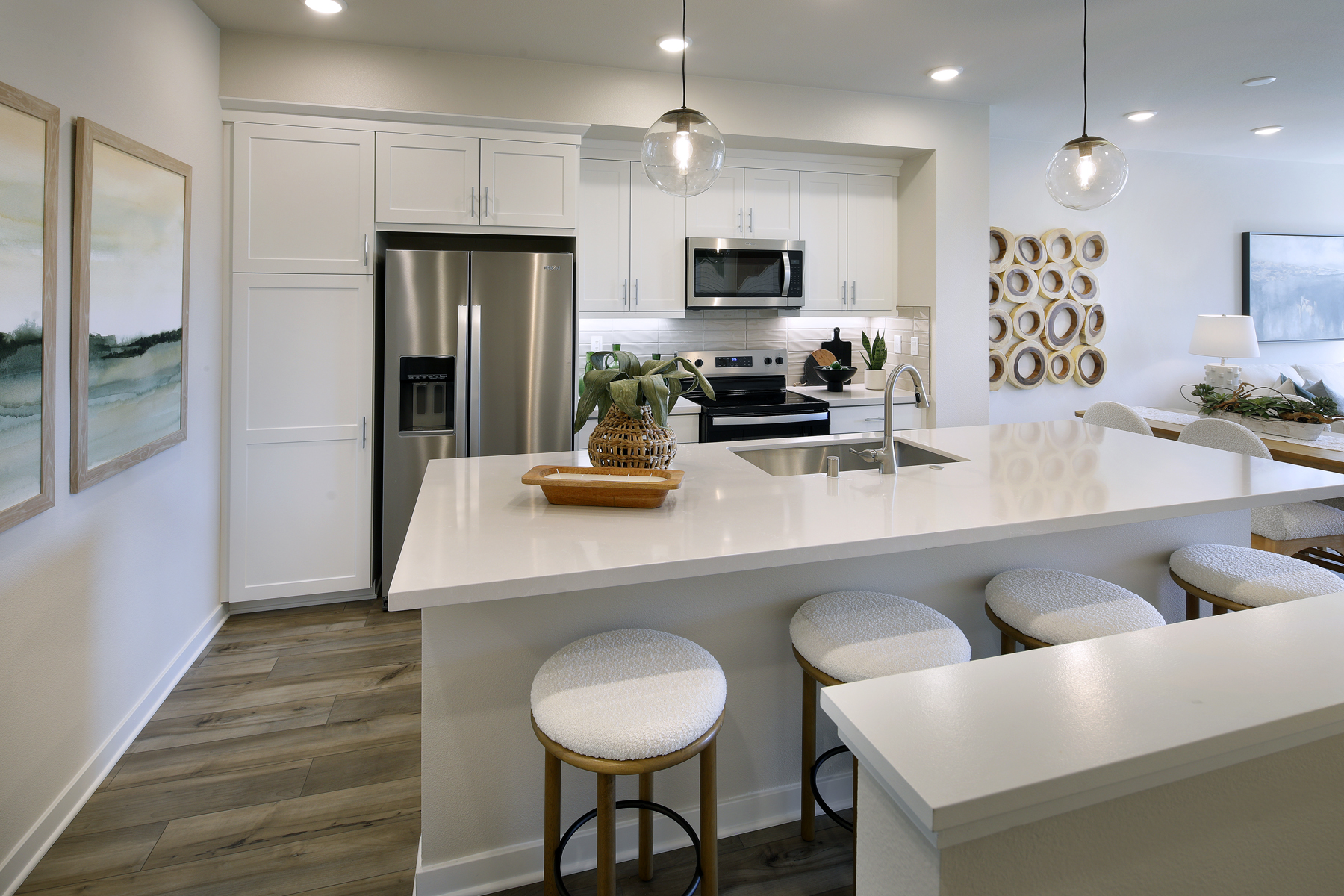 A kitchen with a bar stool and a white counter top.