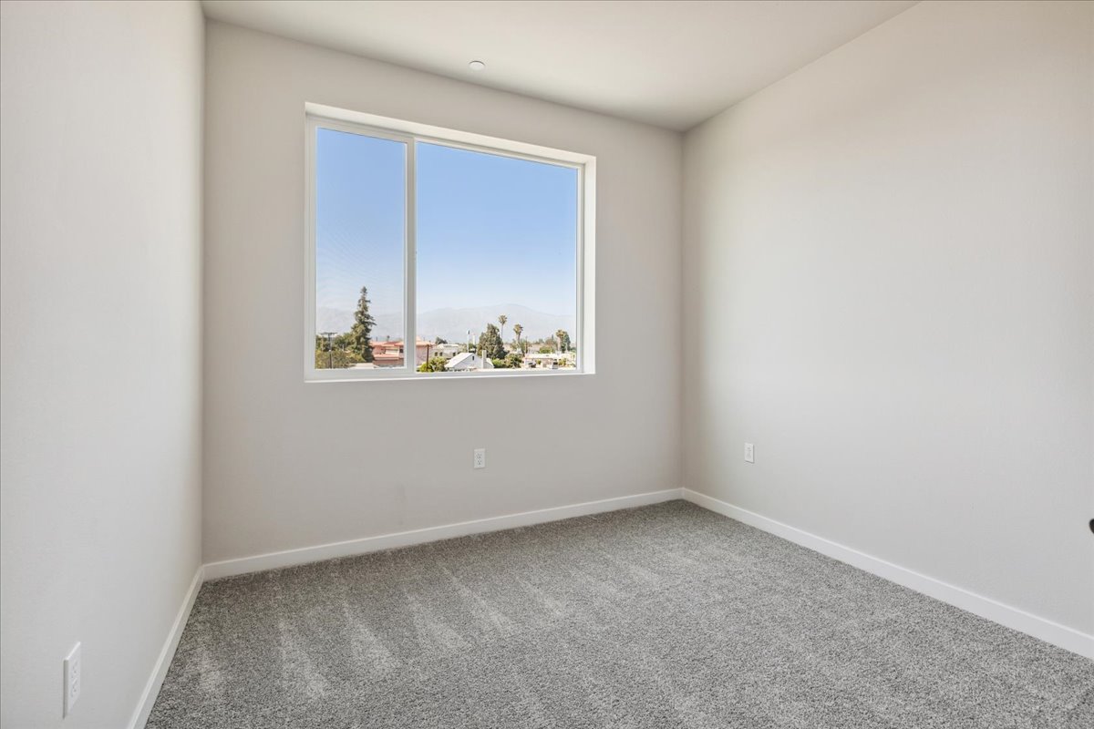 A room with a window and a rug.