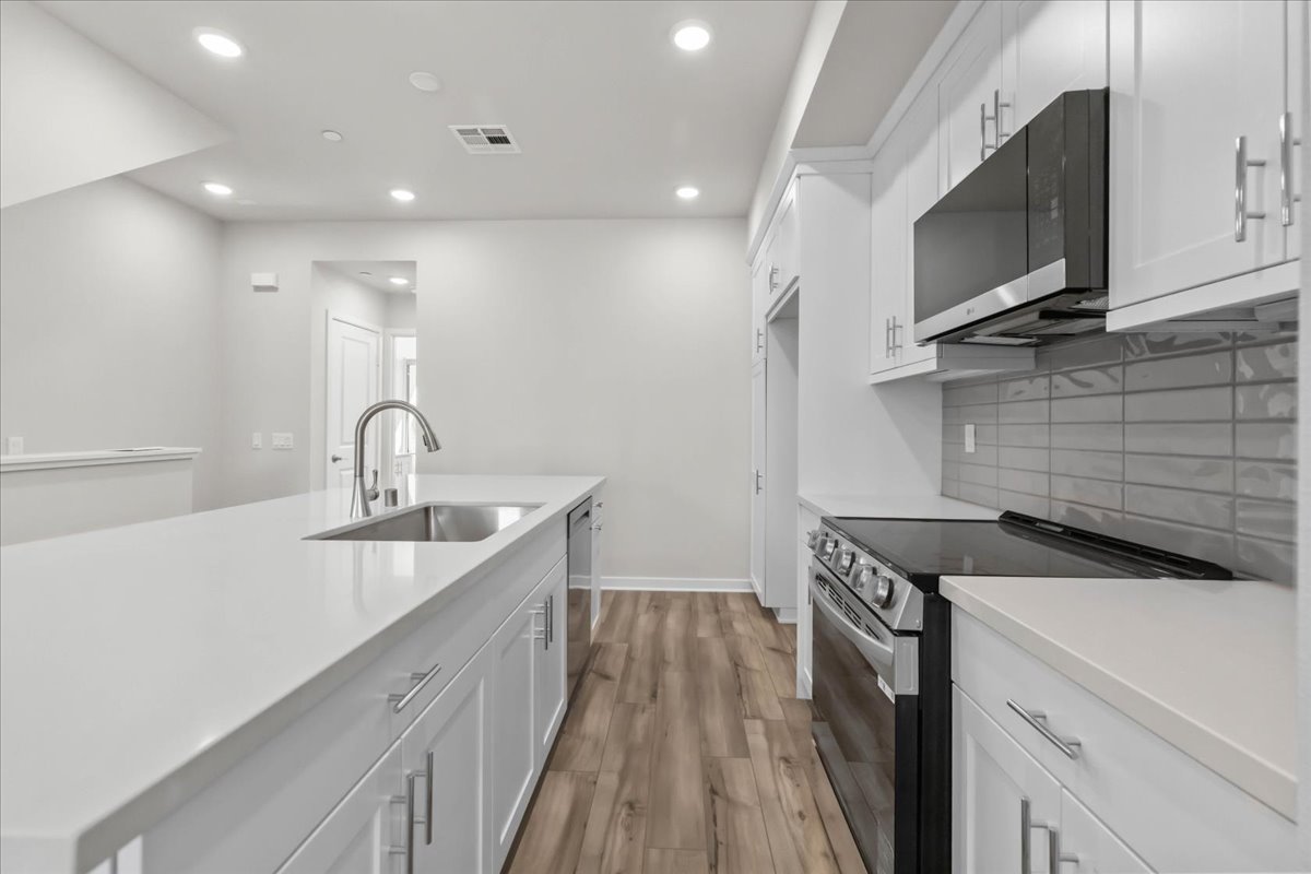 A kitchen with white cabinets.