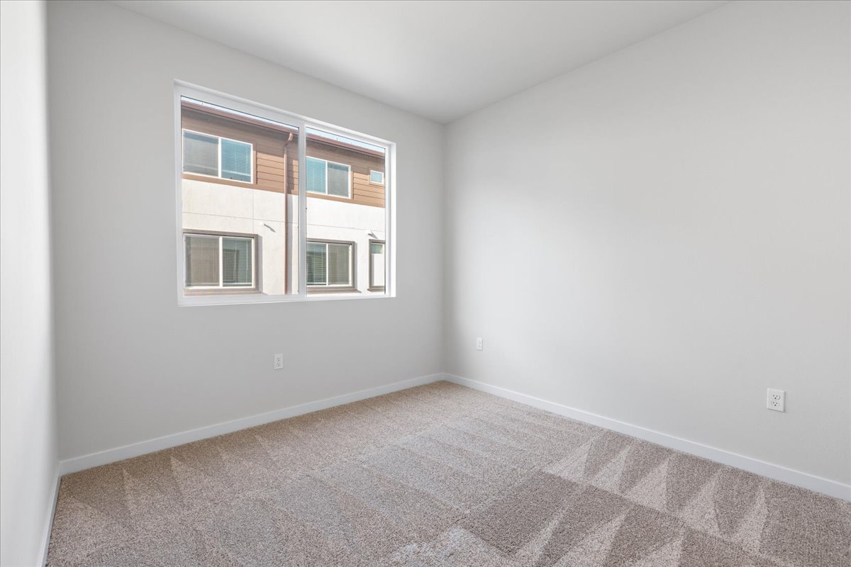 A room with a window and a rug.