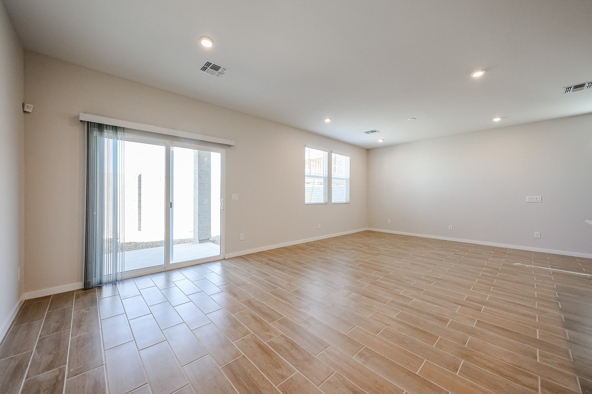 A room with a wood floor and a wood floor with a window.