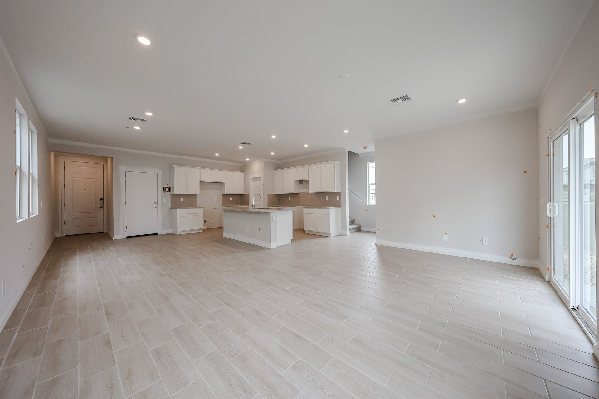 A large empty room with white cabinets.
