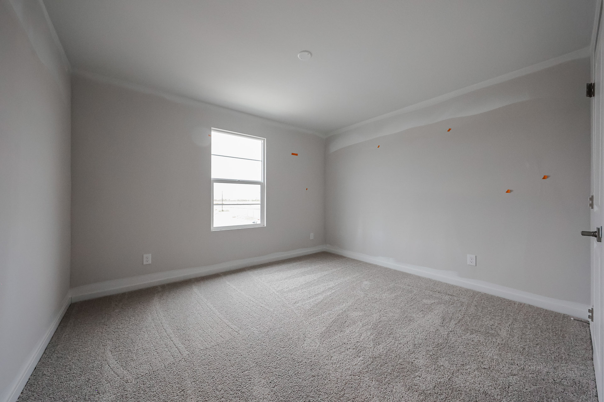 A room with a carpet and a window.