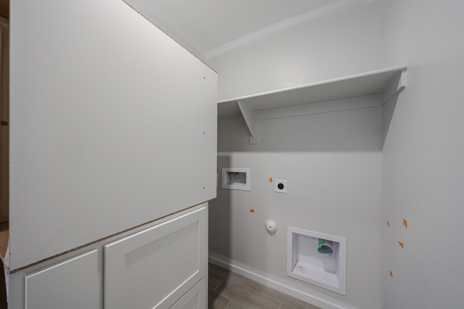 A white wall with a vent and a white door.