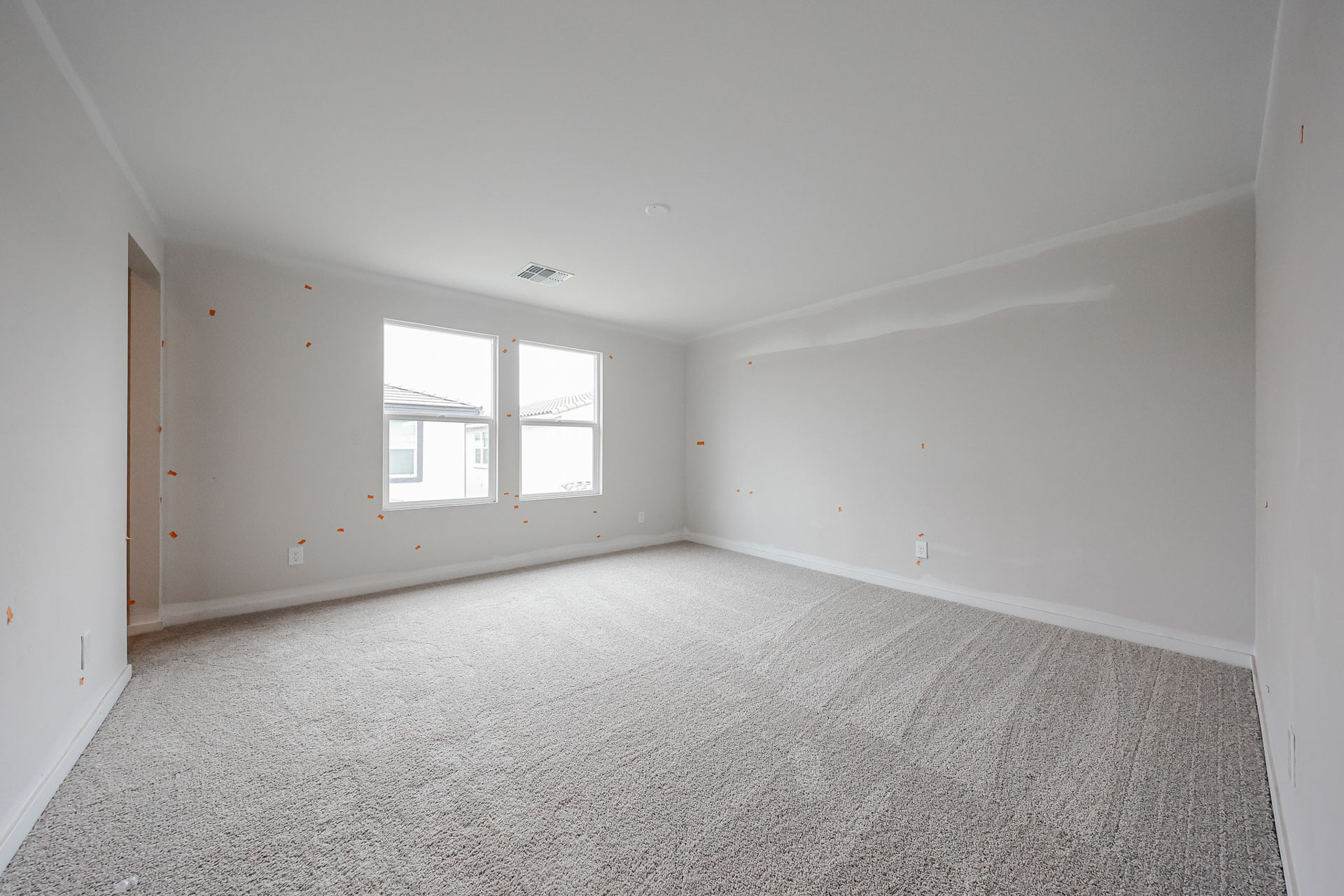 A room with a carpet and windows.