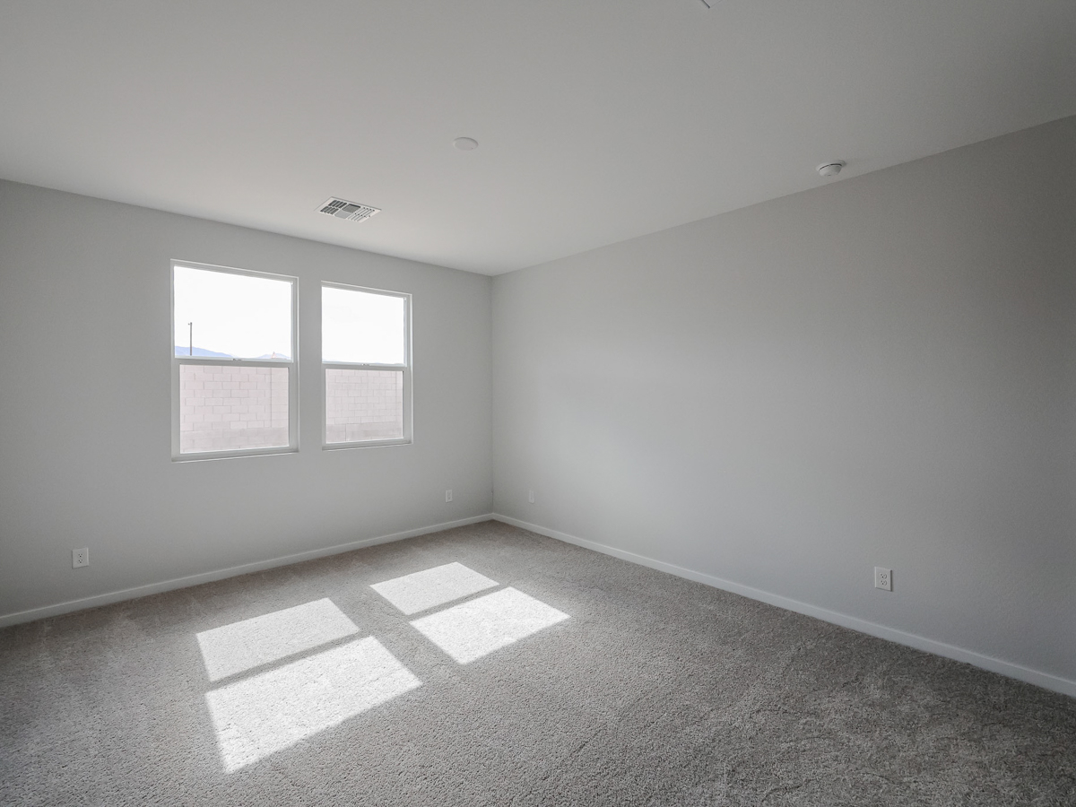 A room with a window and a rug.