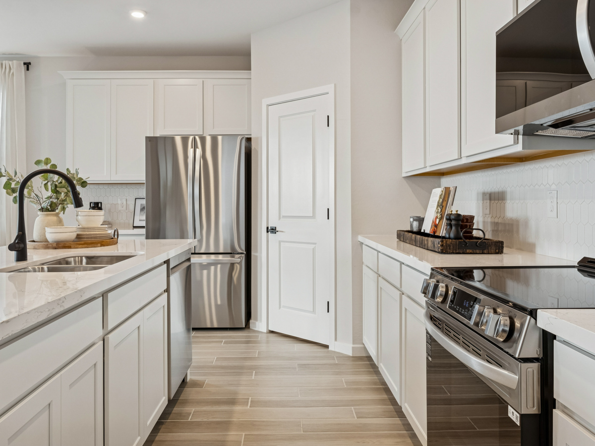 A kitchen with white cabinets.
