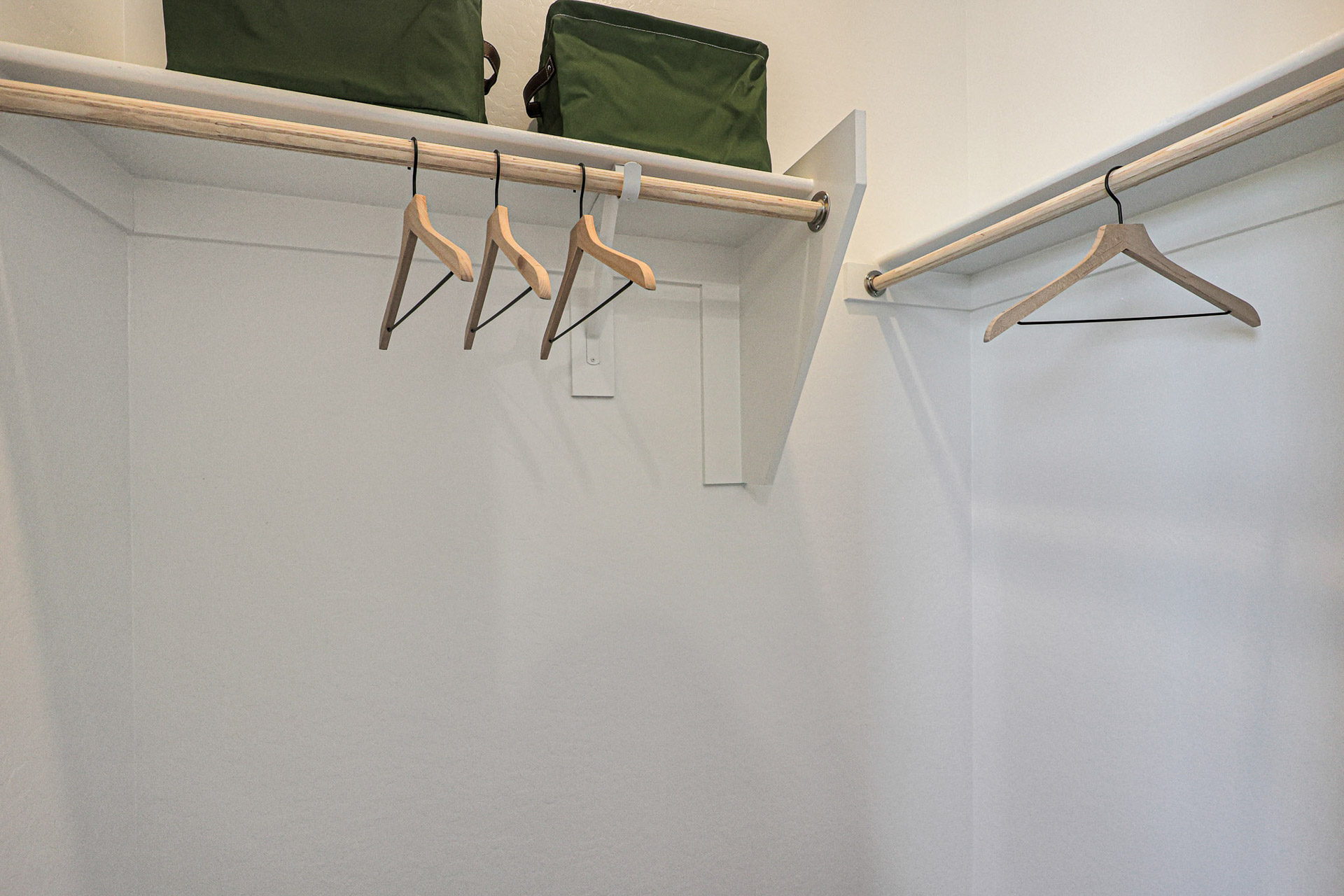 A white wall with a green chair and a green pillow.