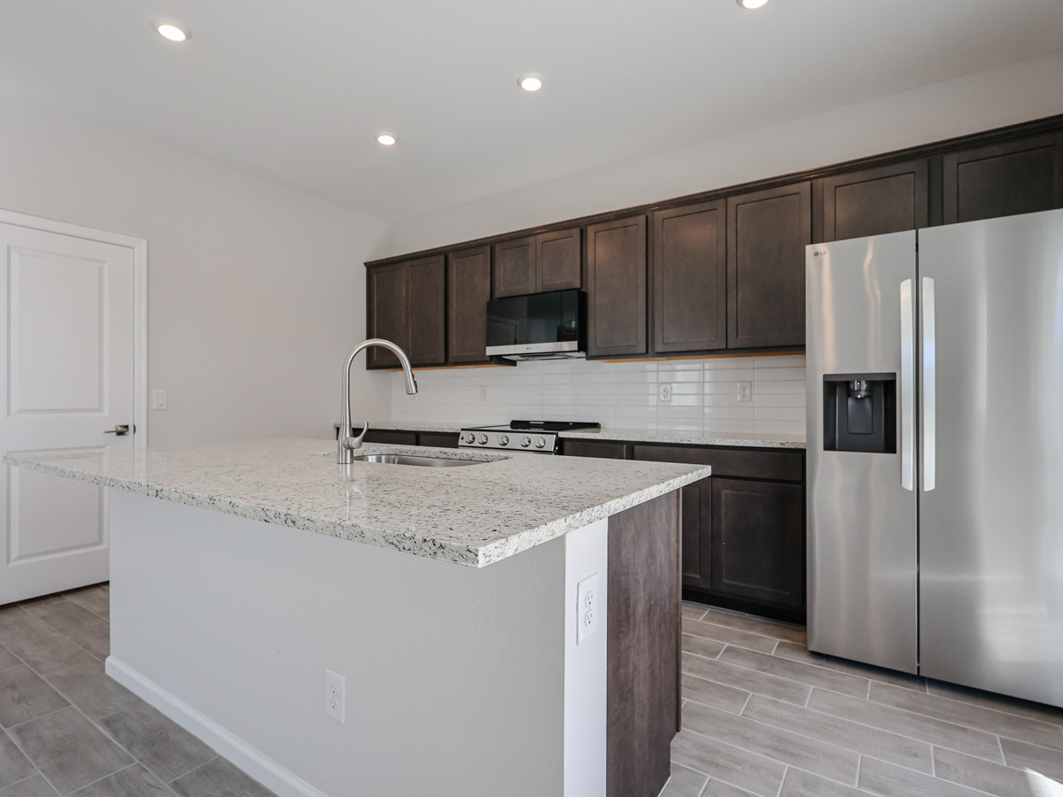 A kitchen with a stainless steel refrigerator.