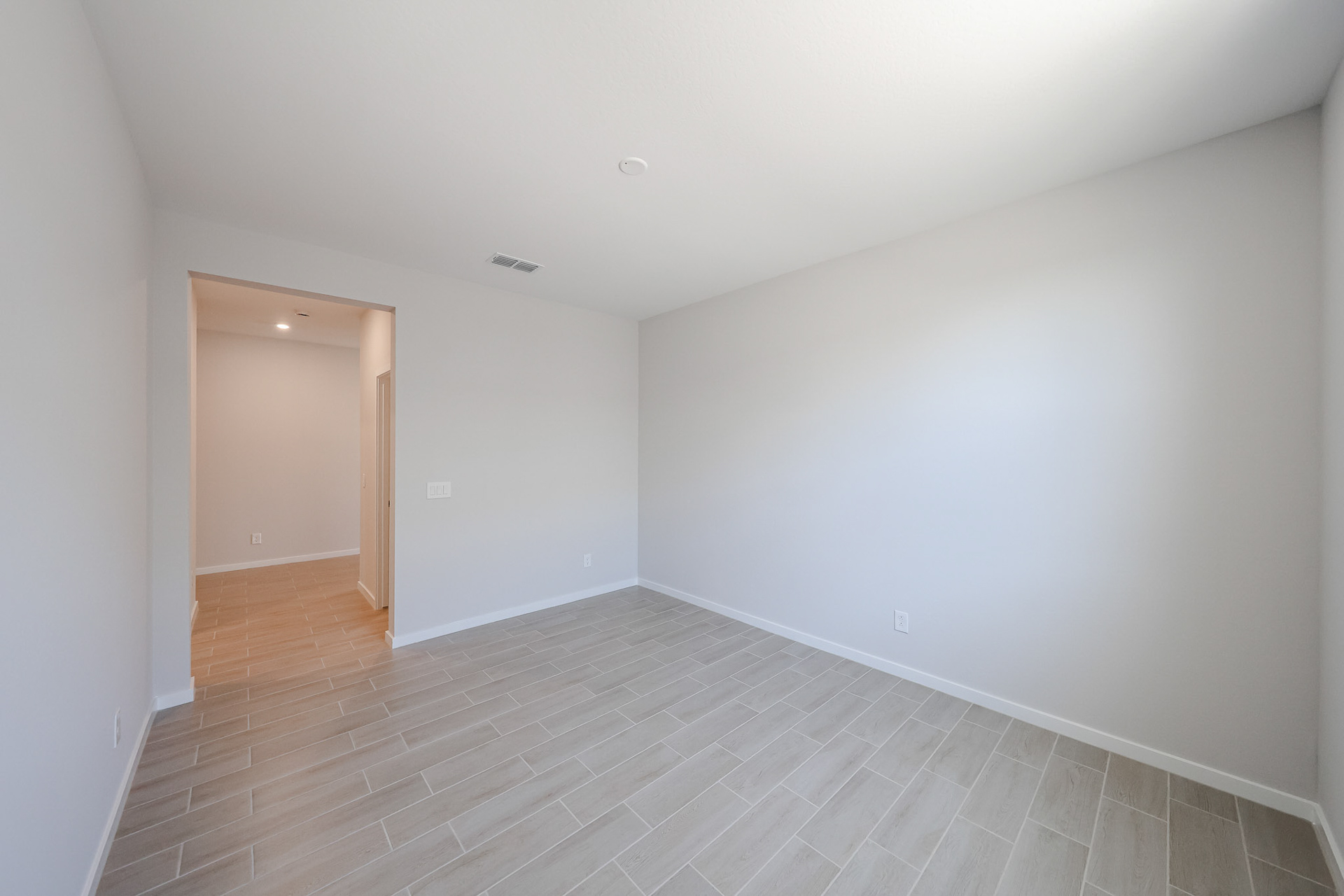 A room with a wood floor and white walls.