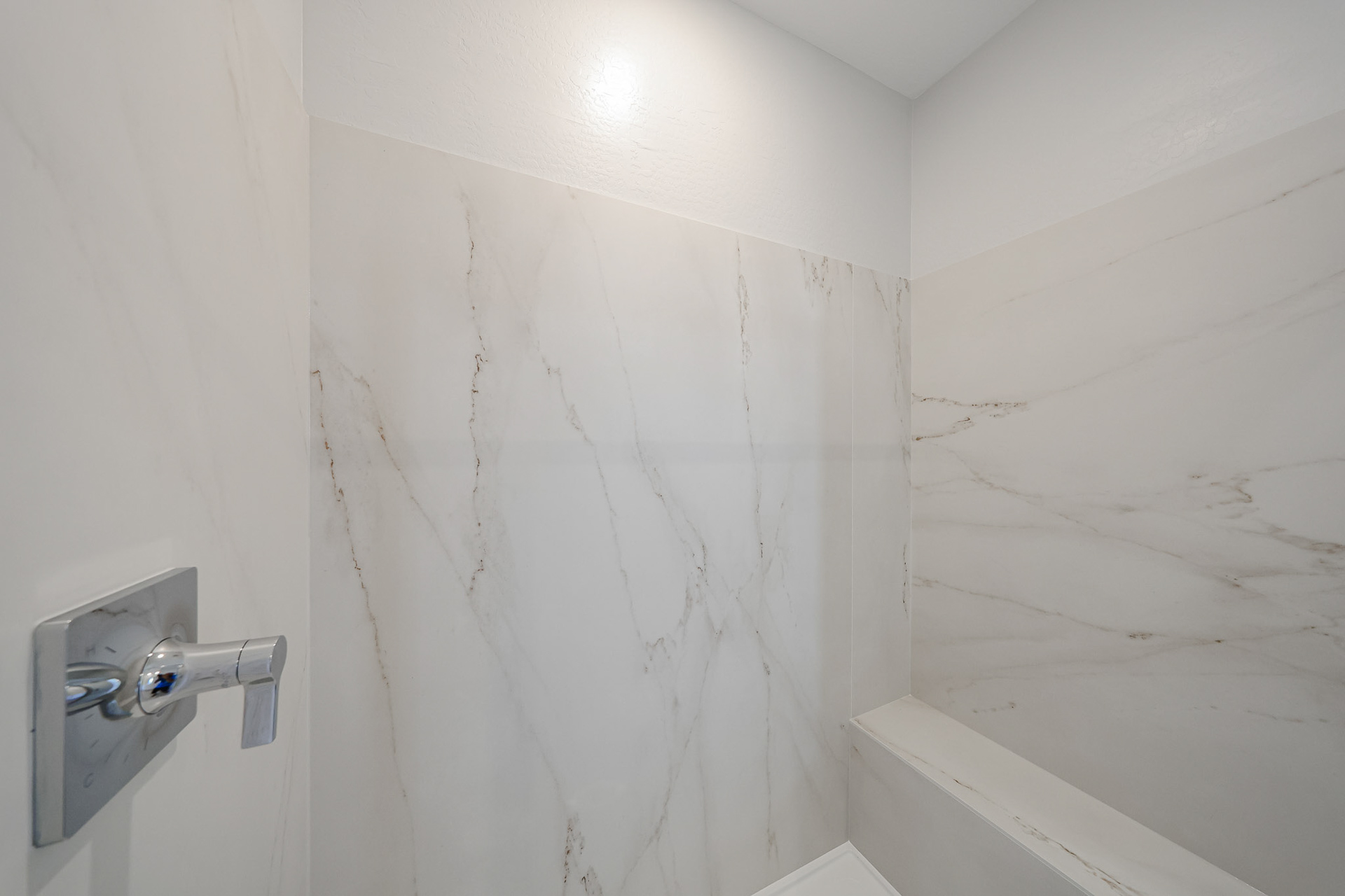 A white wall with a silver door.