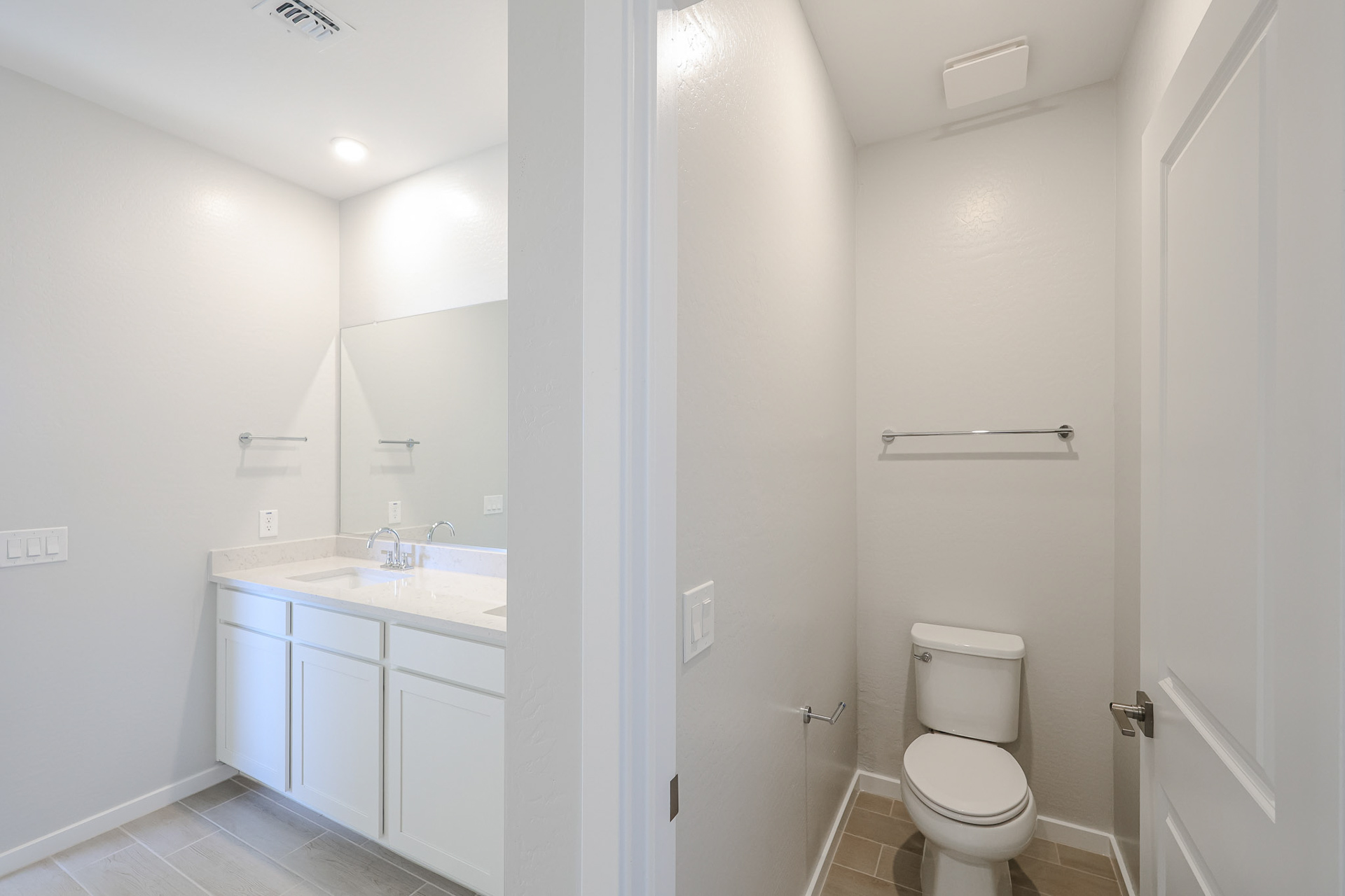 A bathroom with white cabinets.