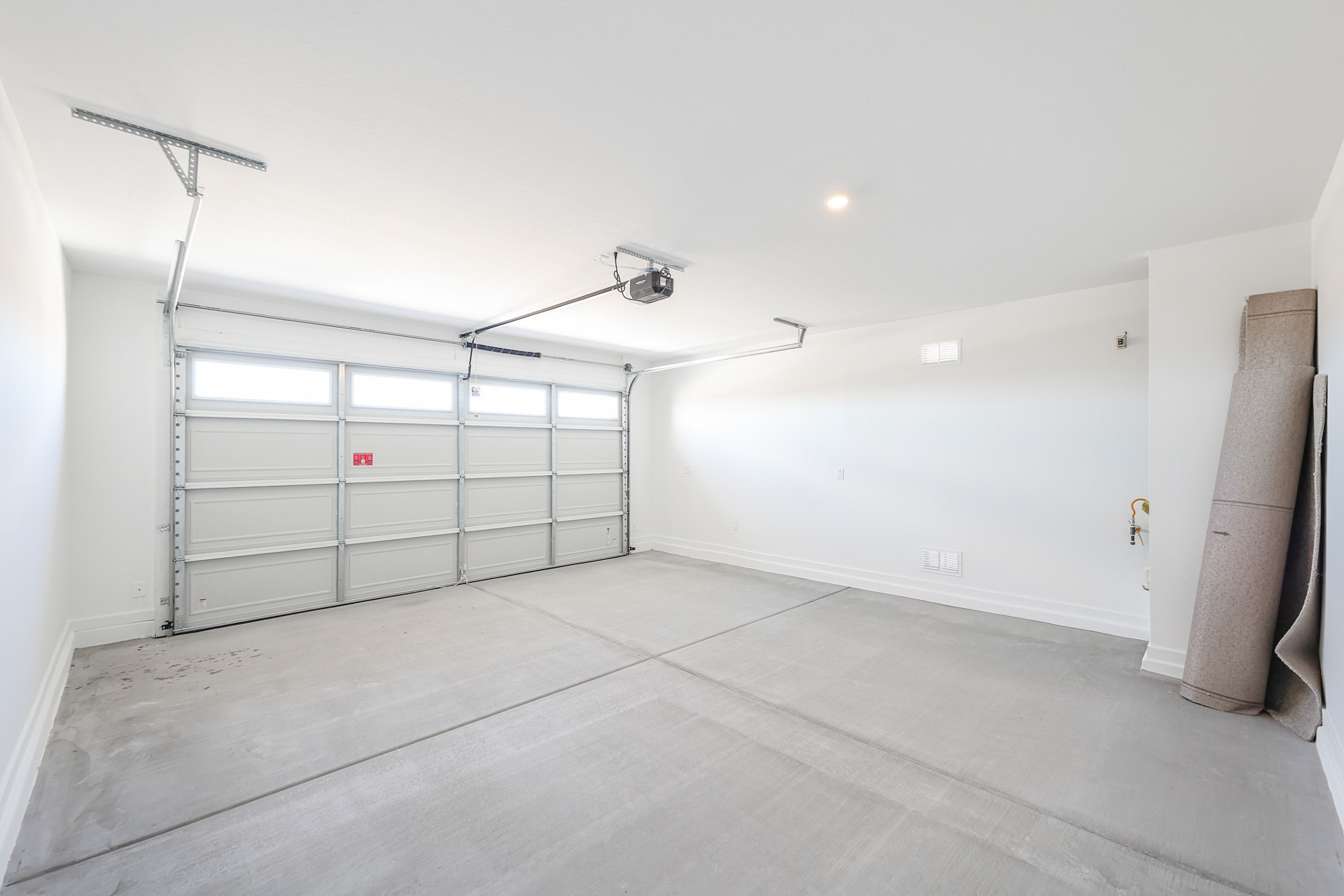 A room with a large white door and a light on the ceiling.