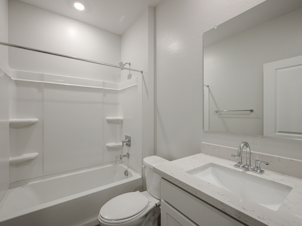 A bathroom with a tub sink and toilet.