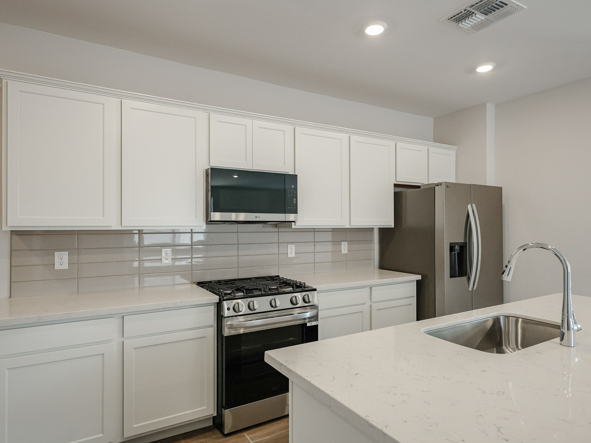 A kitchen with white cabinets.