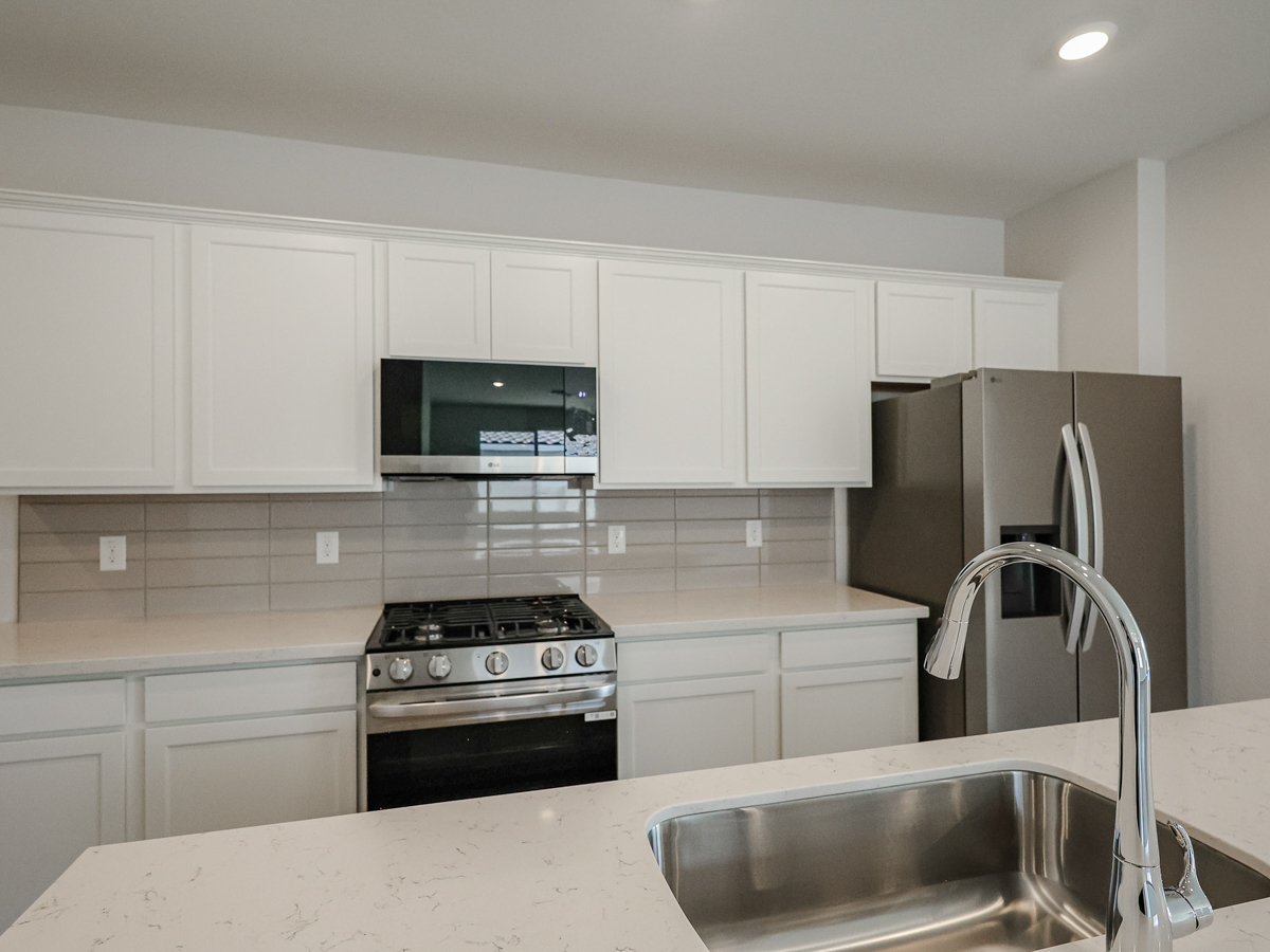 A kitchen with white cabinets.