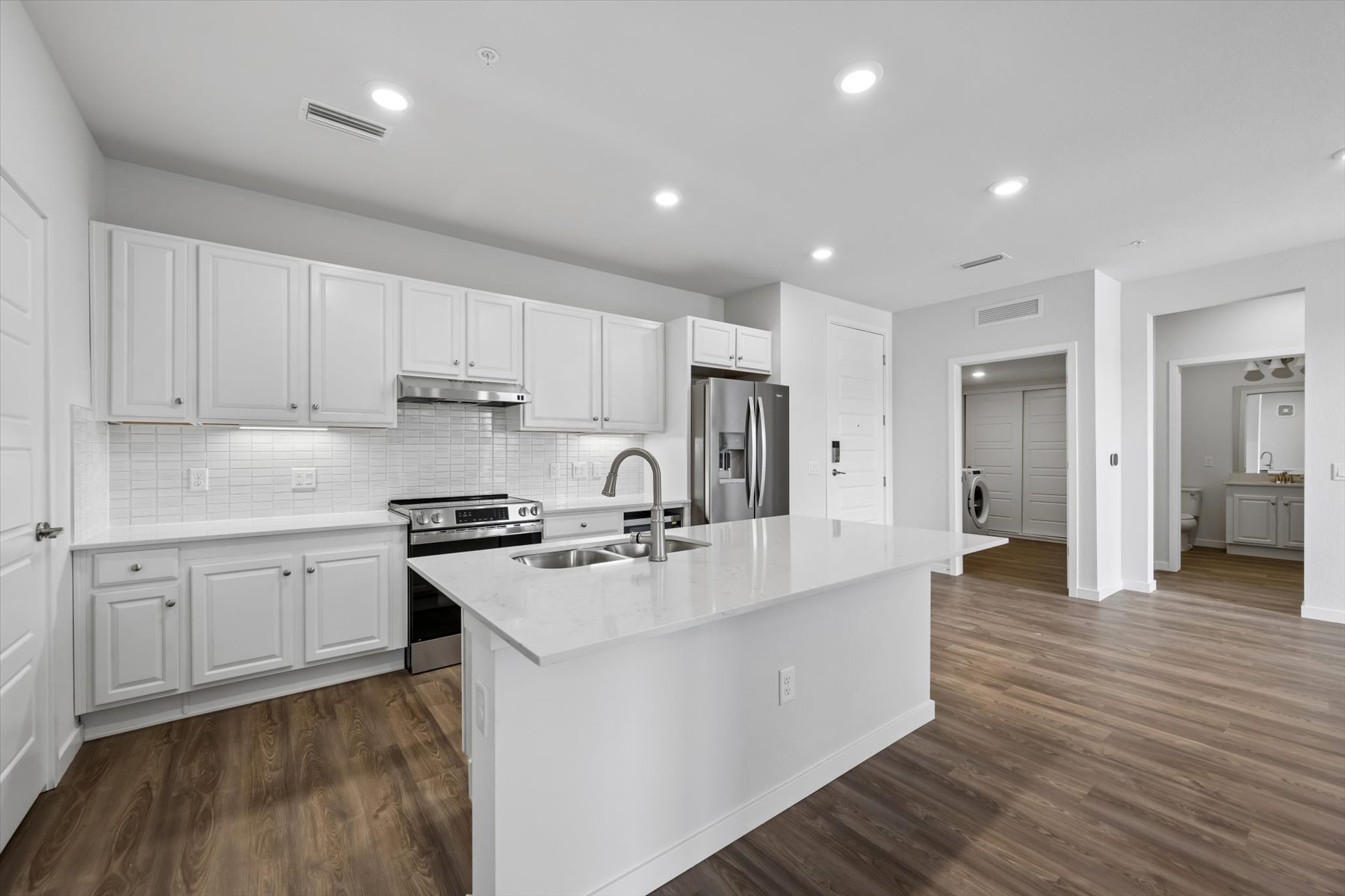 A kitchen with white cabinets.