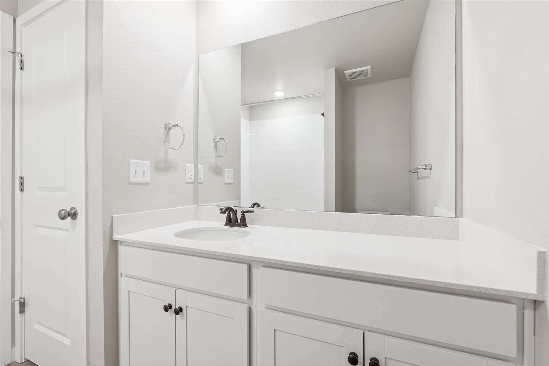 A bathroom with a large mirror.