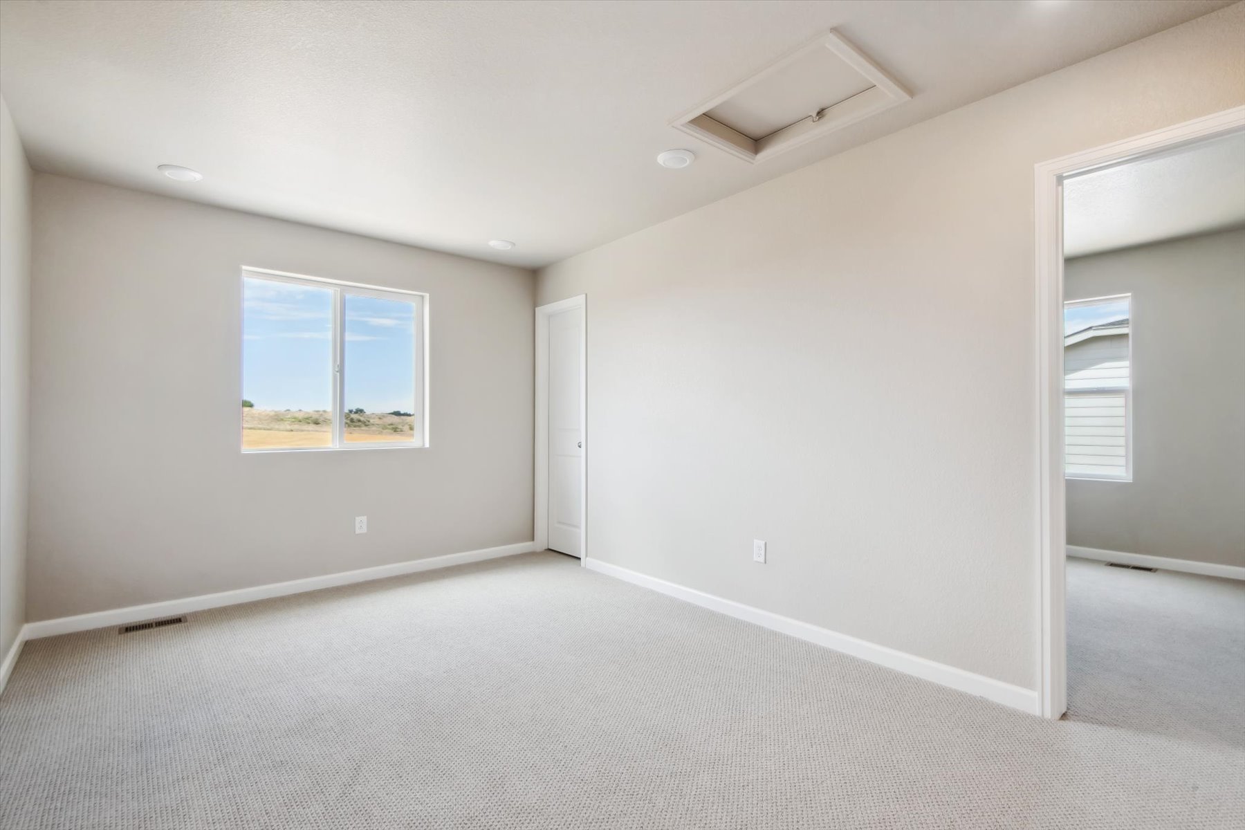 A room with a window and a carpet.
