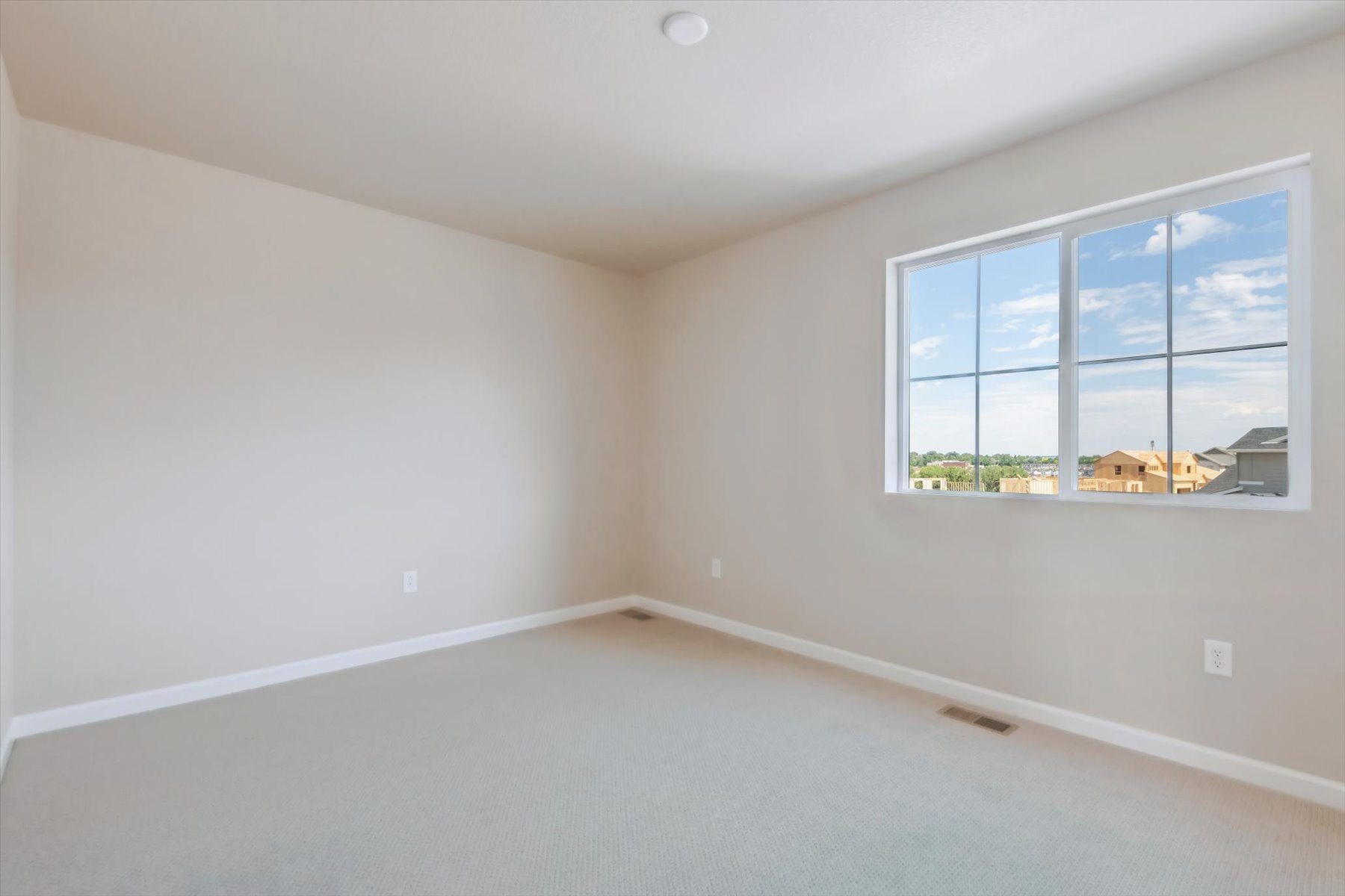 A room with a window and a white wall.