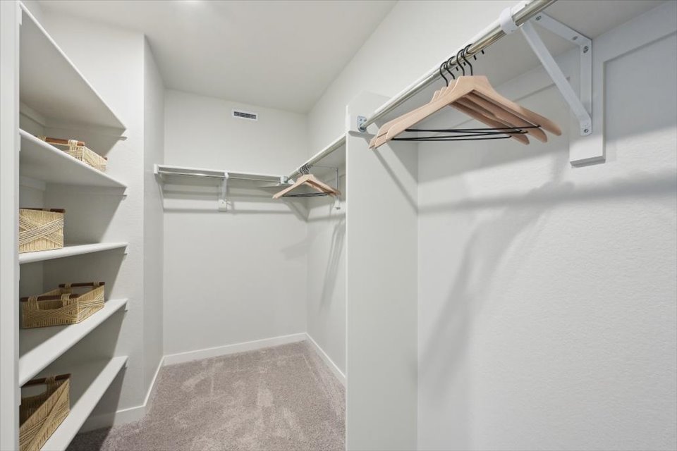 A white room with shelves.