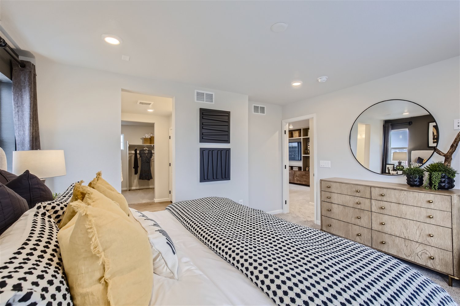 A bedroom with a bed and a mirror.