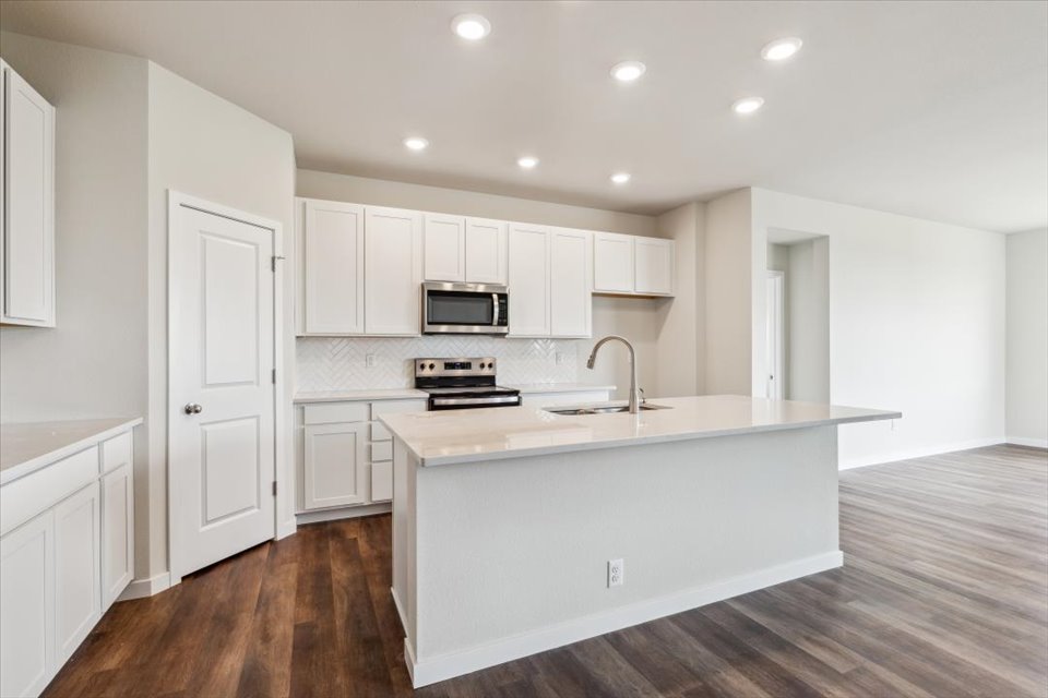 A kitchen with white cabinets.