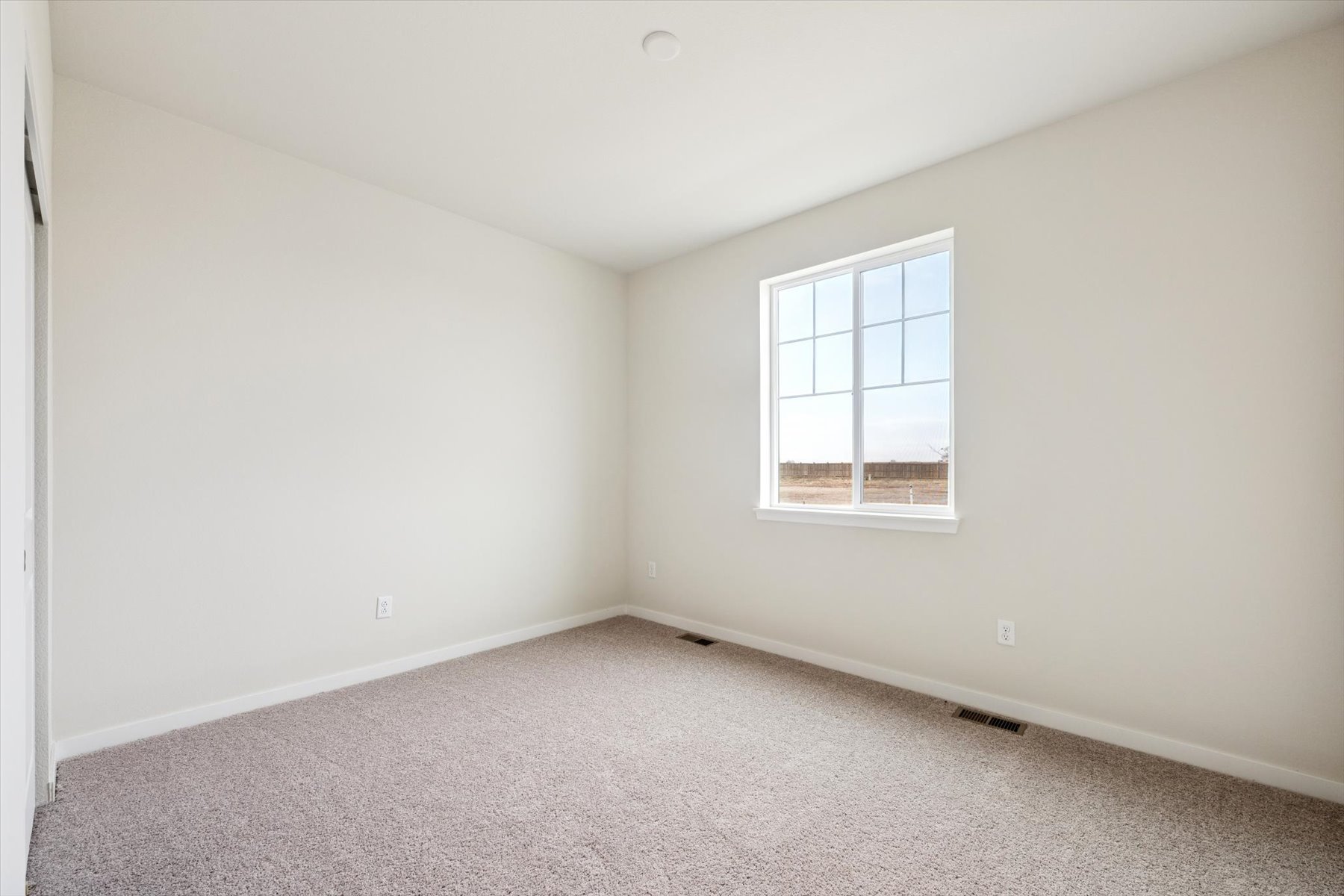 A room with a window and a carpet.