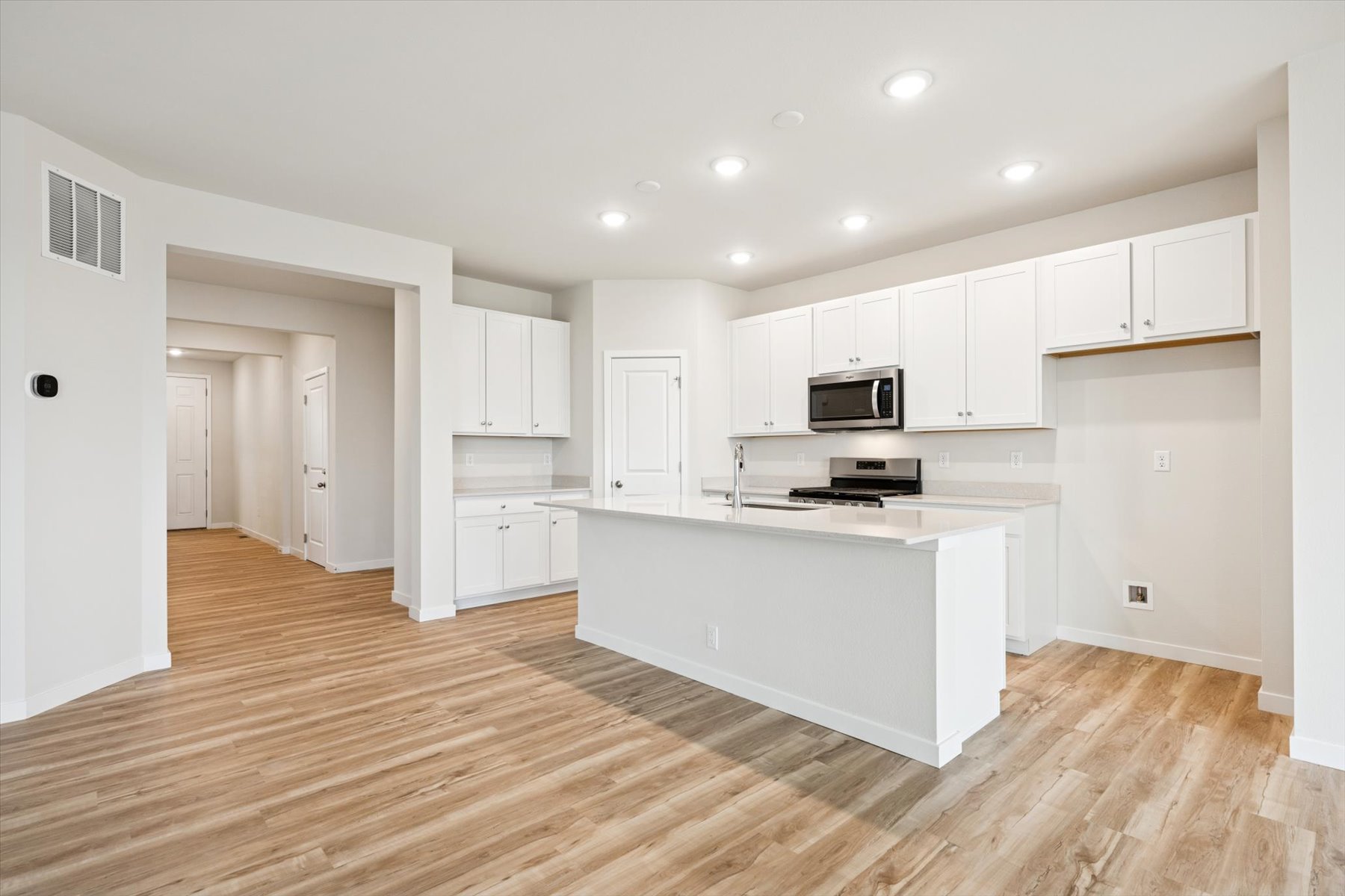 A kitchen with white cabinets.