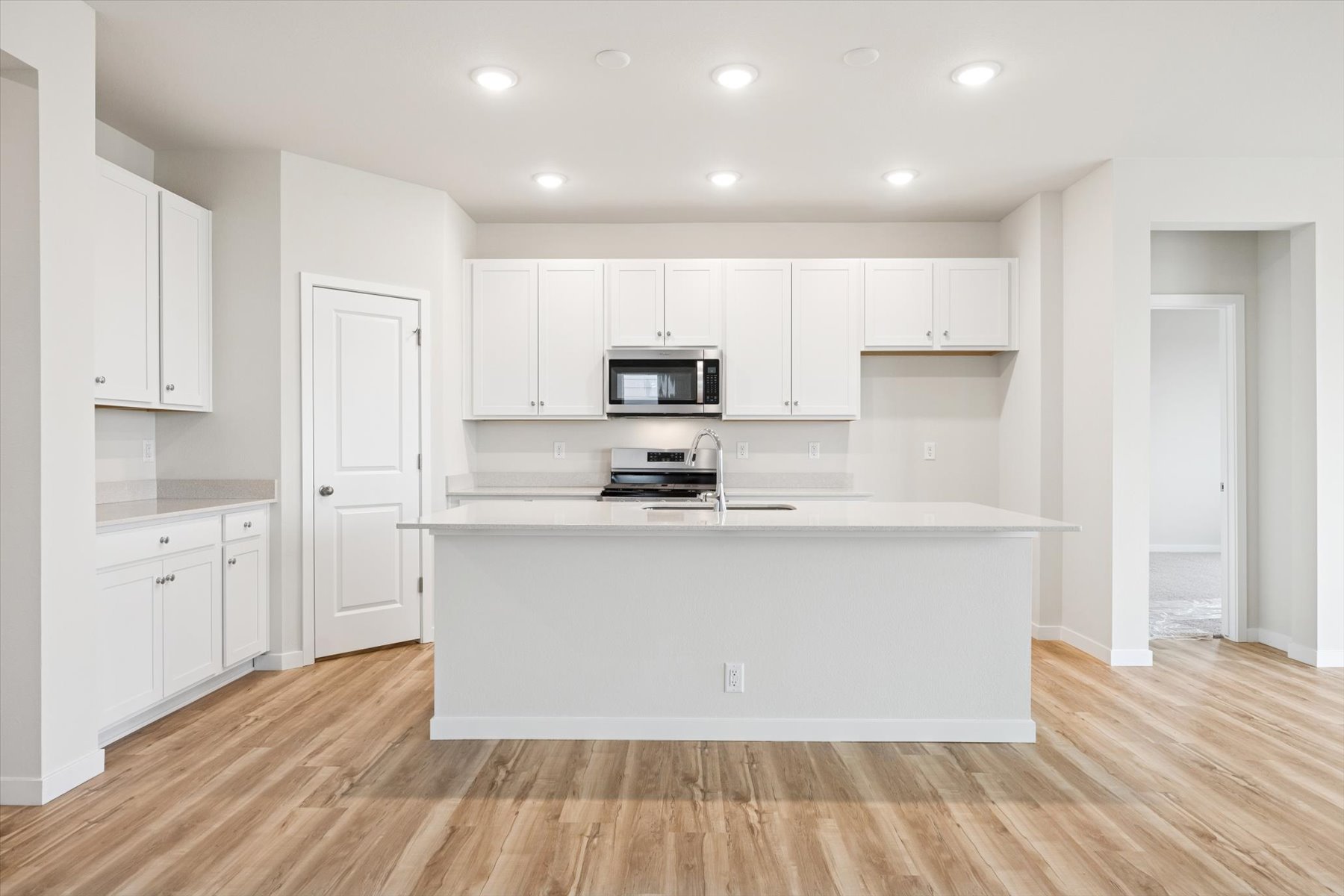 A kitchen with white cabinets.
