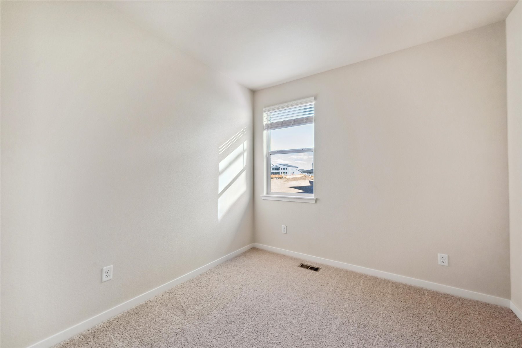A room with a window and a carpet.