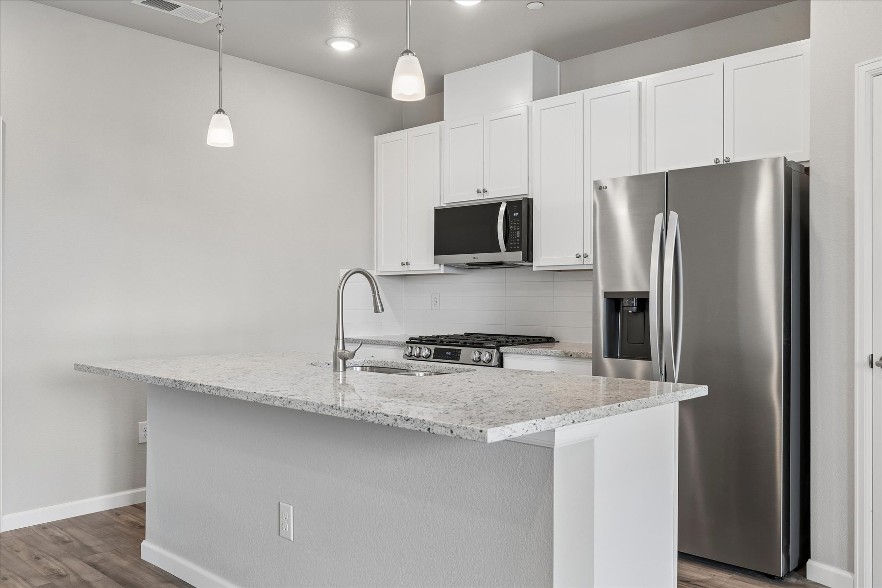 A kitchen with white cabinets.