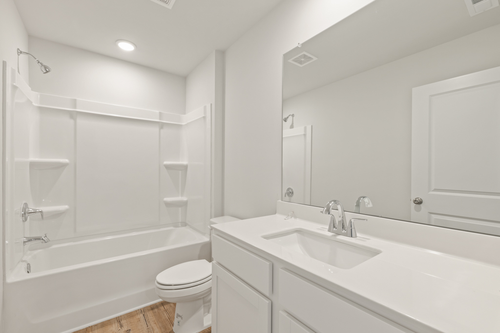 A bathroom with a tub sink and toilet.