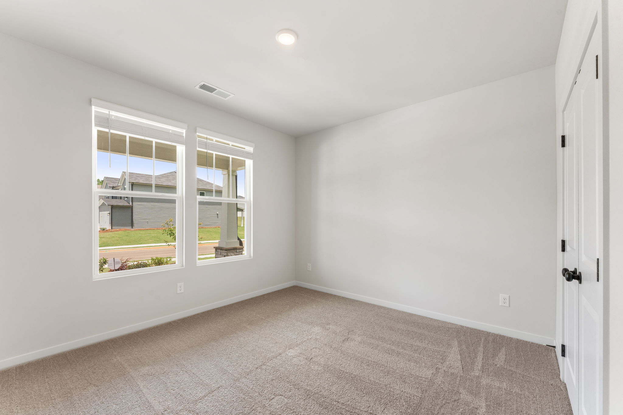 A room with a window and a carpet.