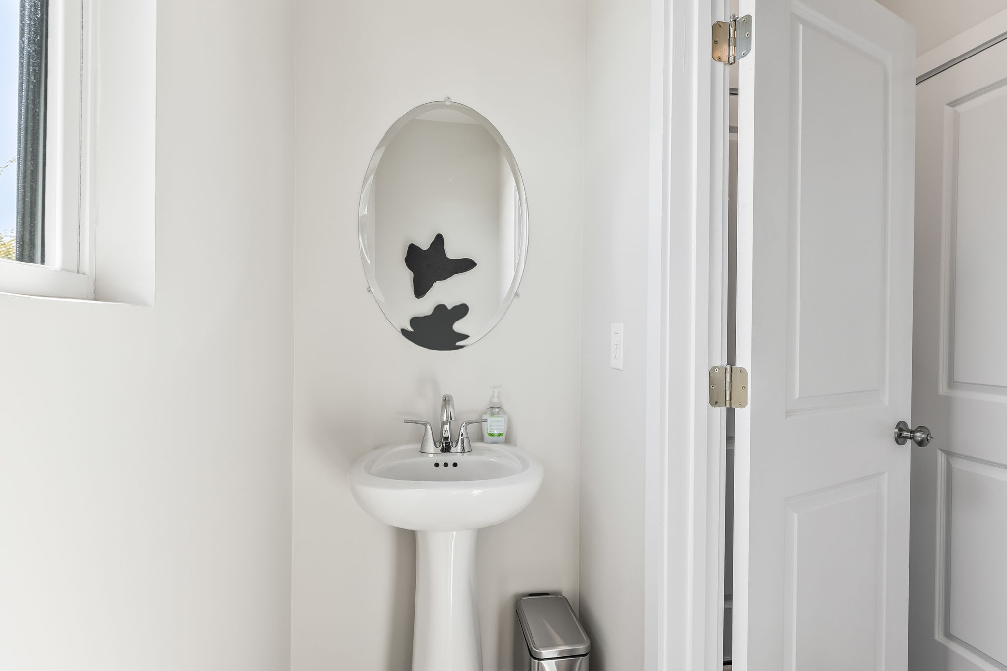 A bathroom with a round mirror.