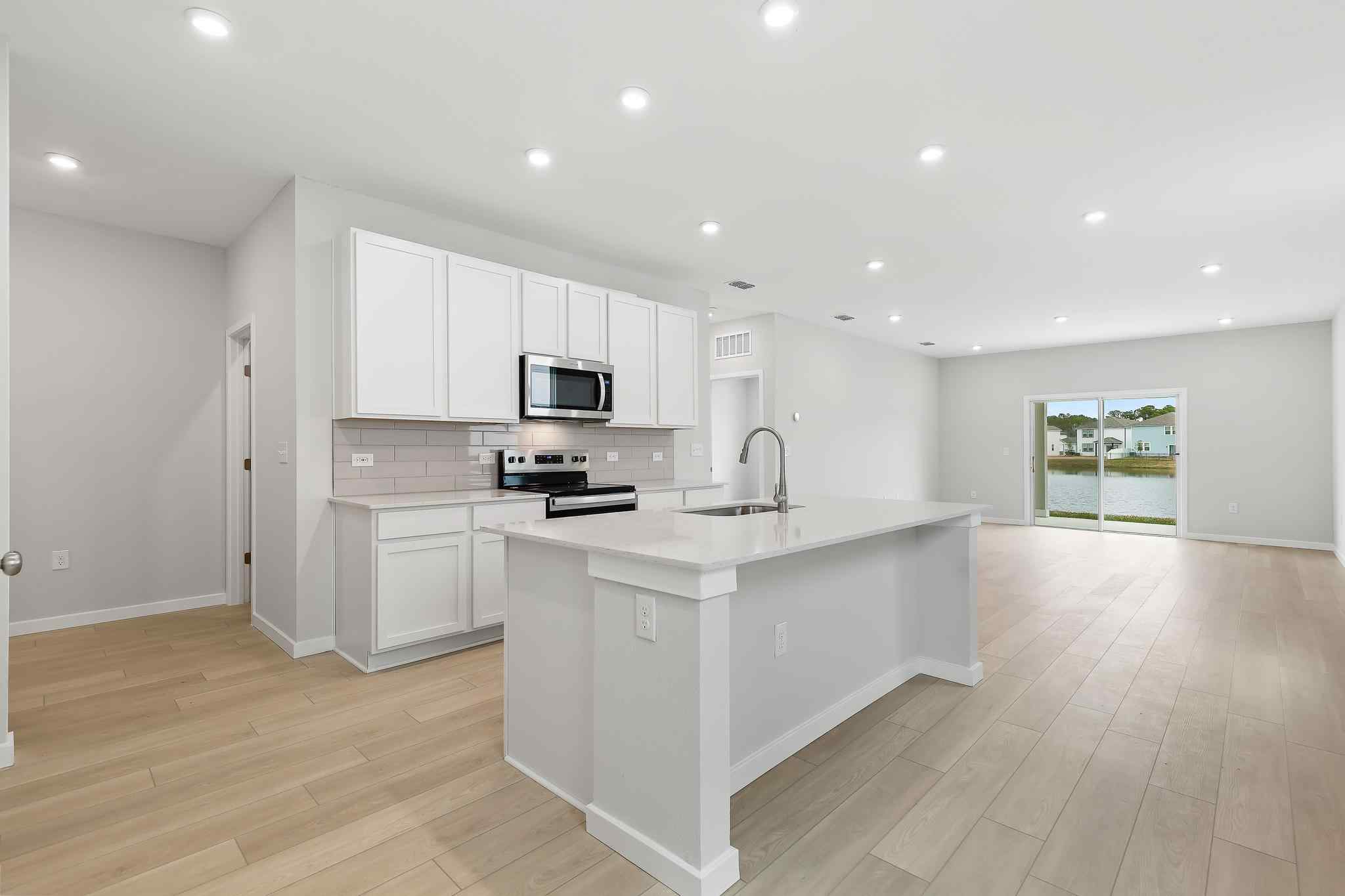 A kitchen with white cabinets.