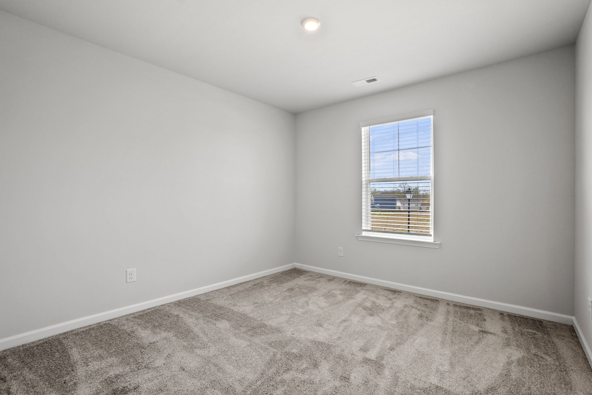 A room with a window and a carpet.