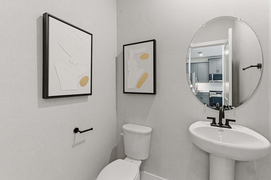 A bathroom with a toilet and a mirror.