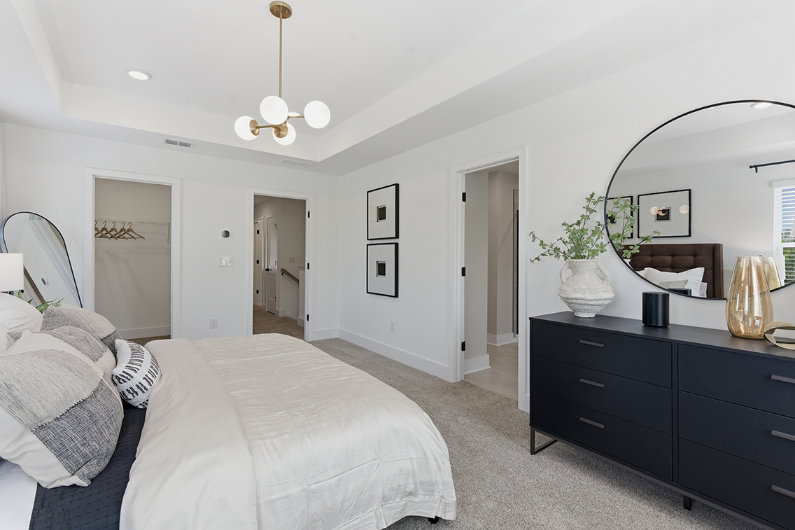 A bedroom with a bed and a mirror.