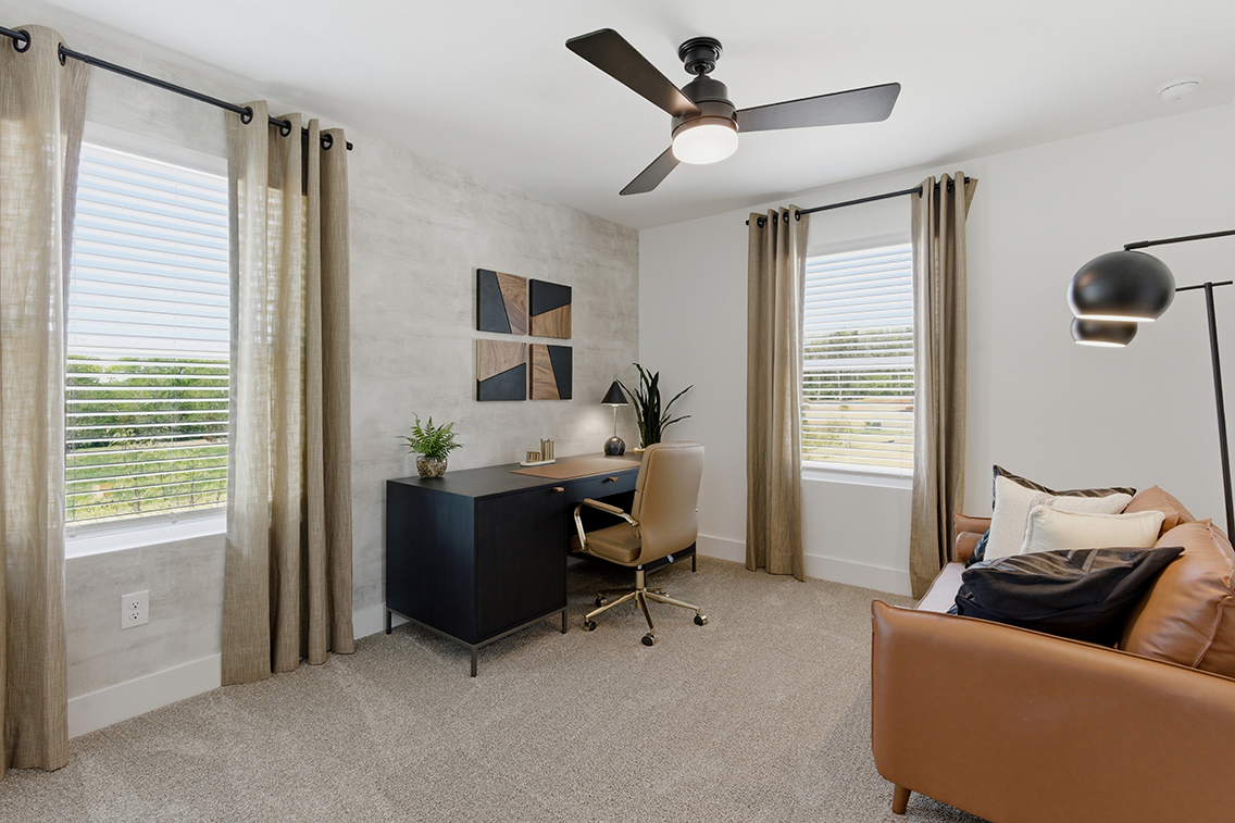 A living room with a fan and a couch.