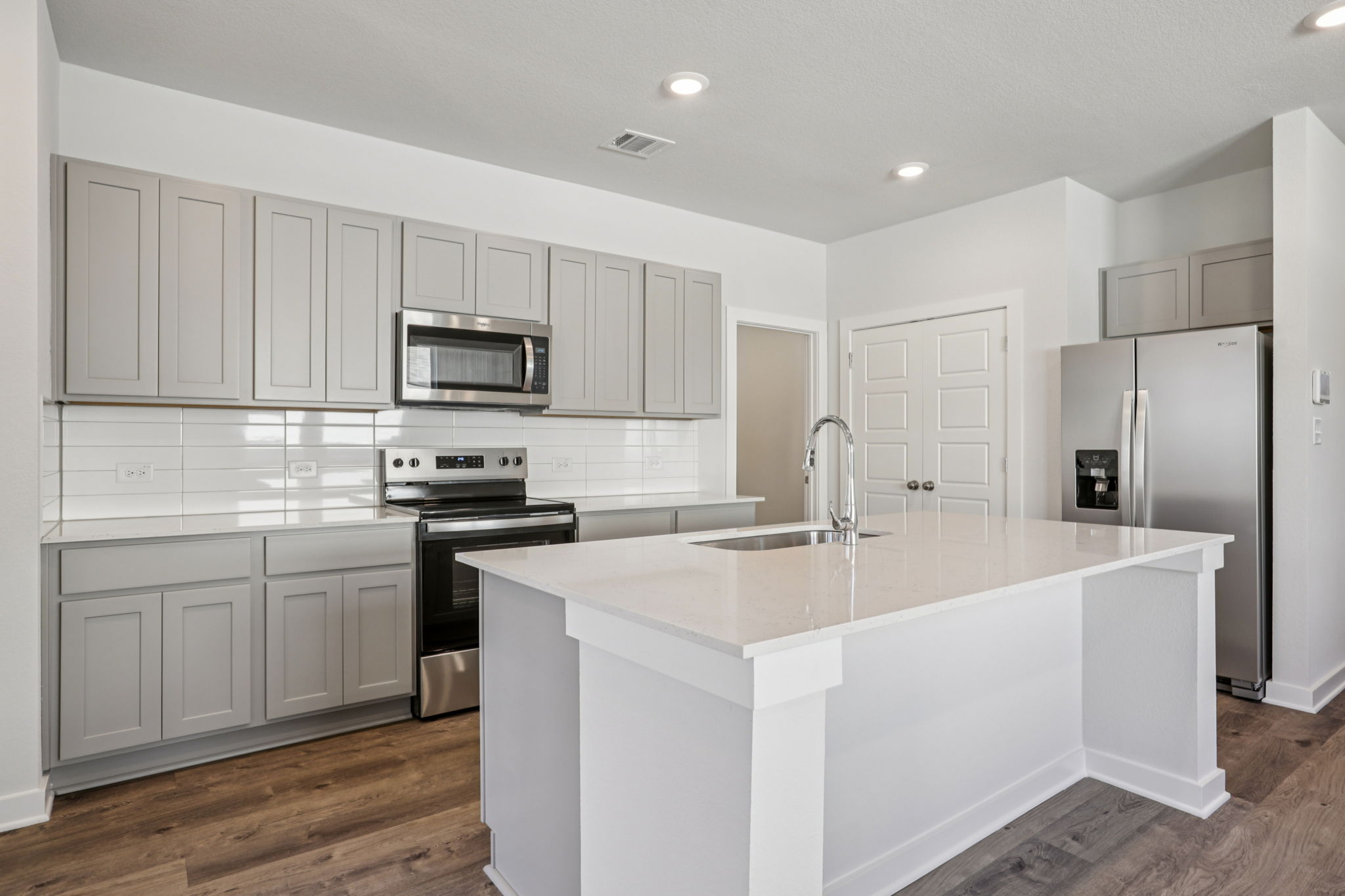 A kitchen with white cabinets.