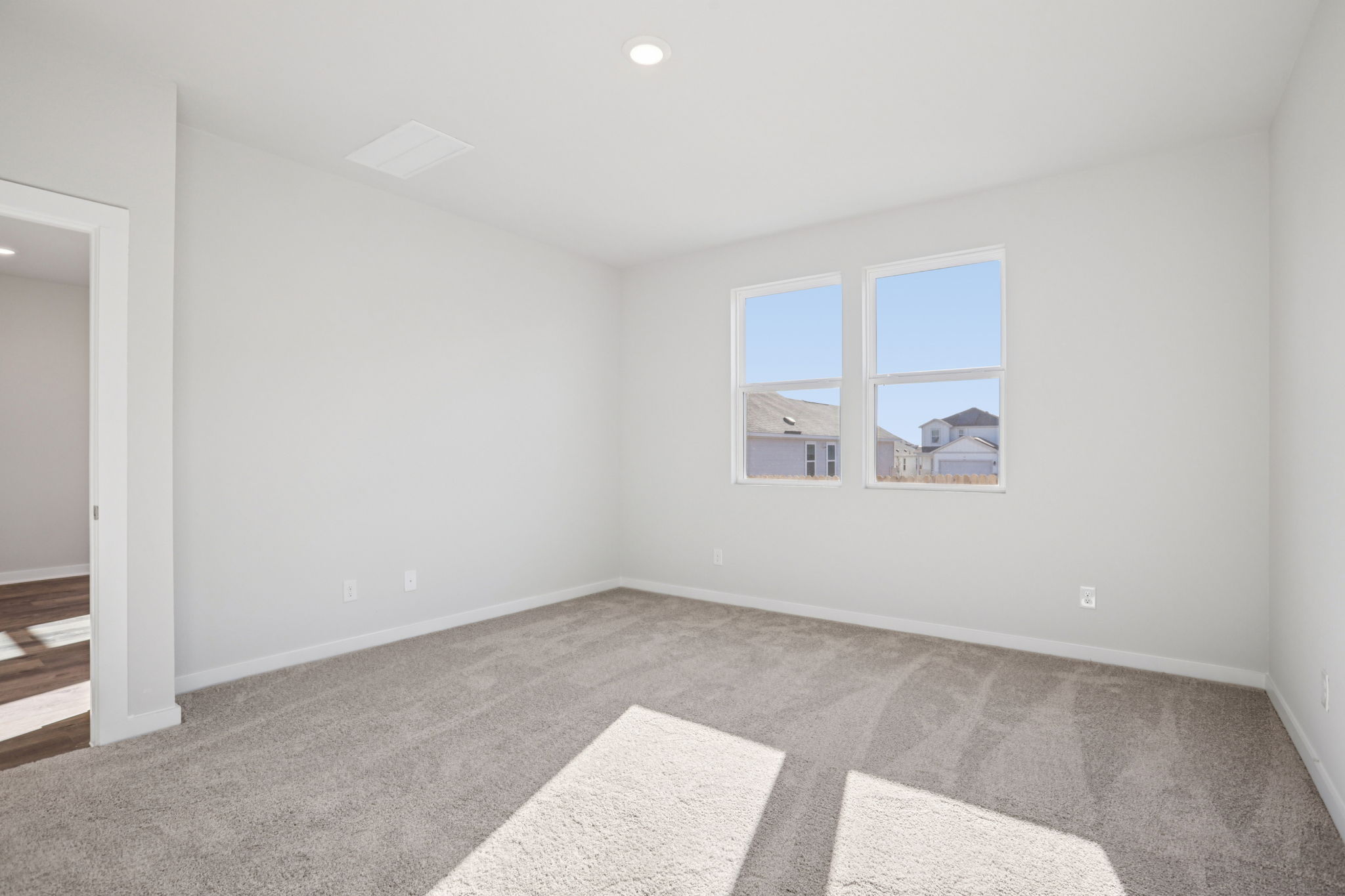 A room with a window and a rug.