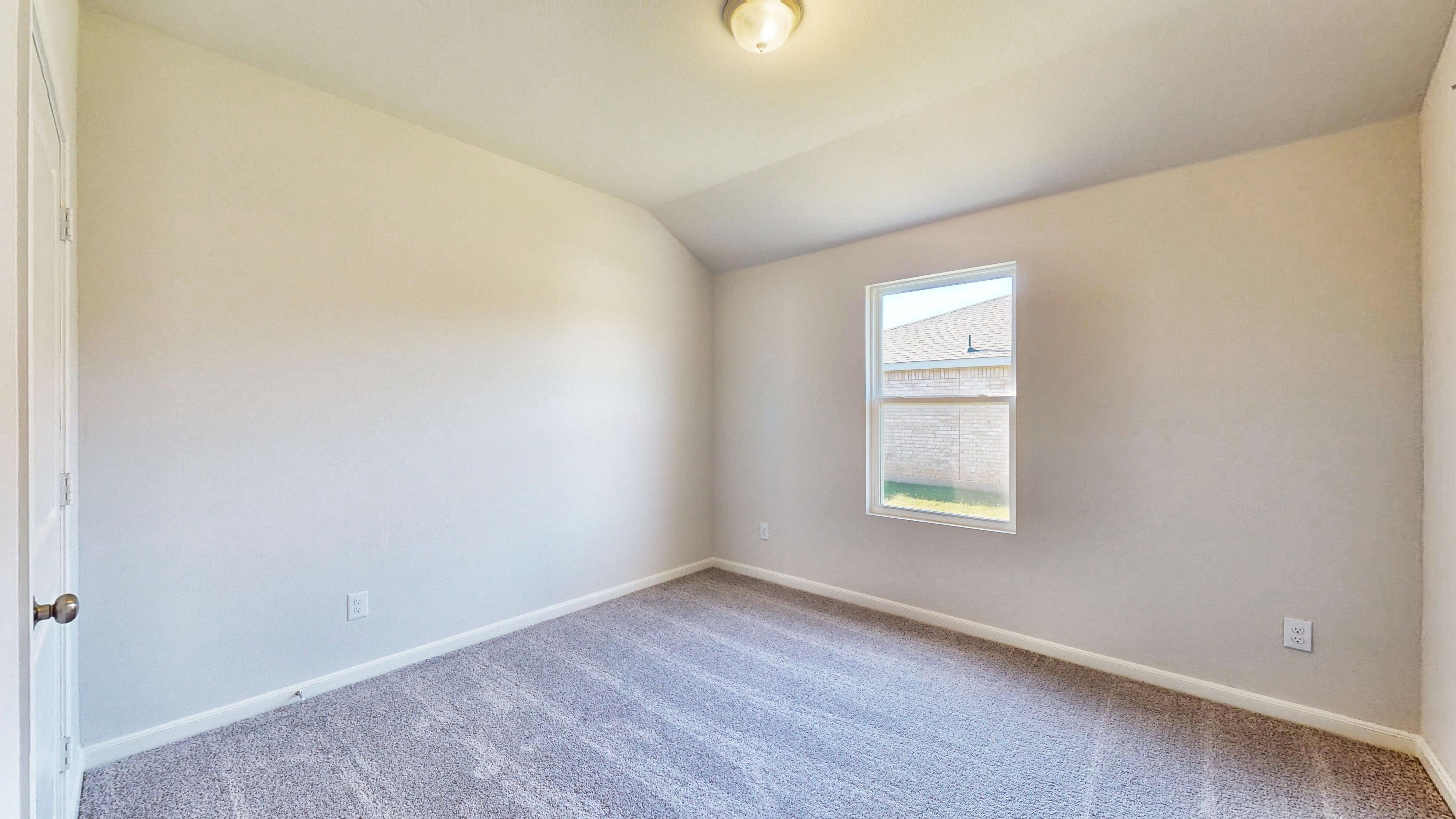 A room with a carpet and a window.
