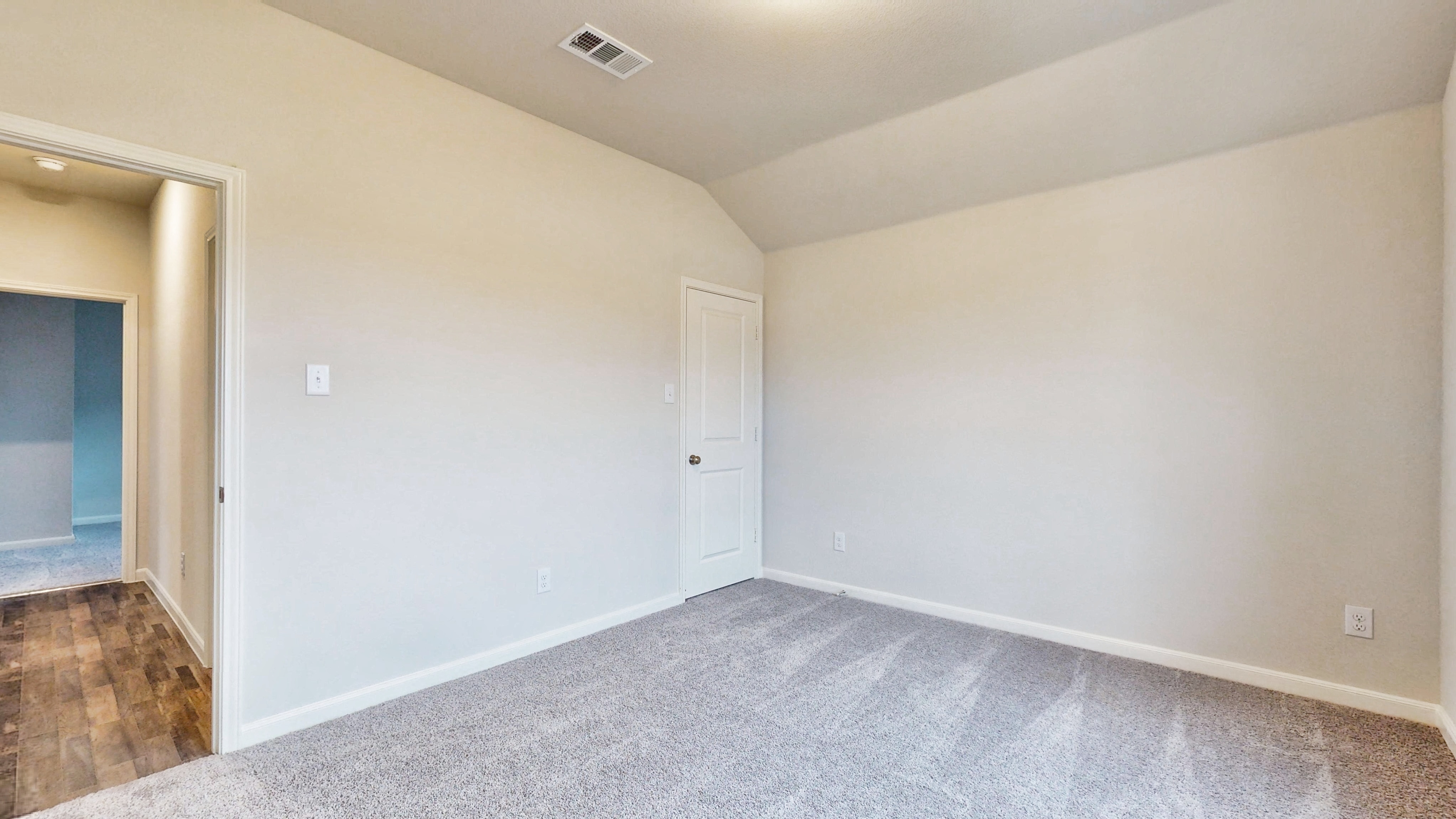 A room with a white door and a white wall.