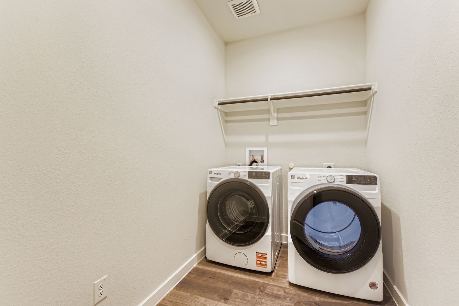 A white room with a washing machine and a dryer.